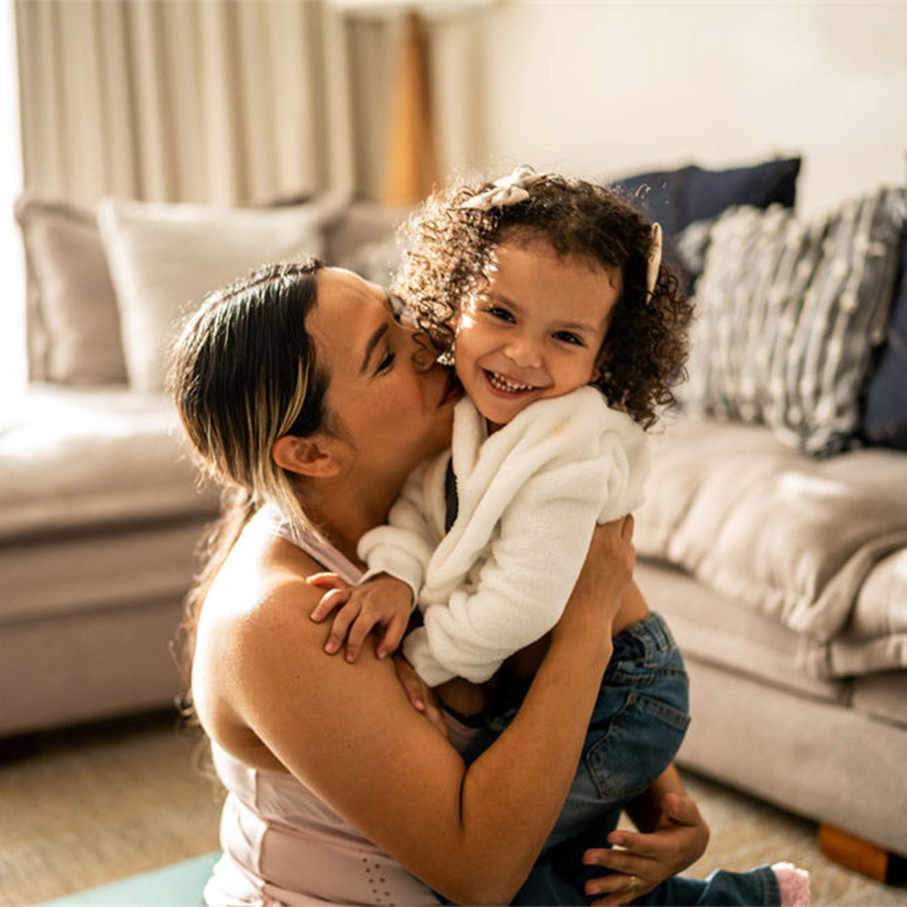 Portrait of toddler girl having fun with her mother in the living room at home