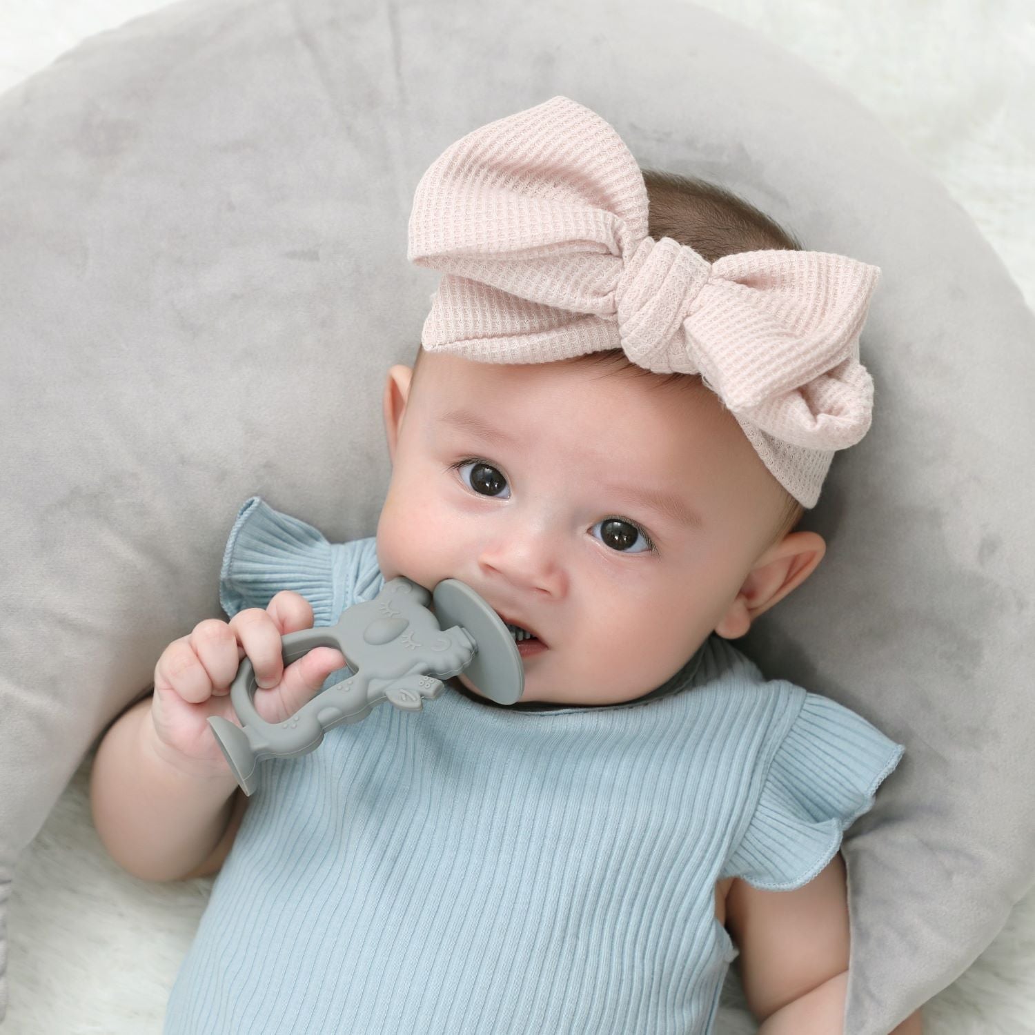 A baby is using Moonkie's koala teether.
