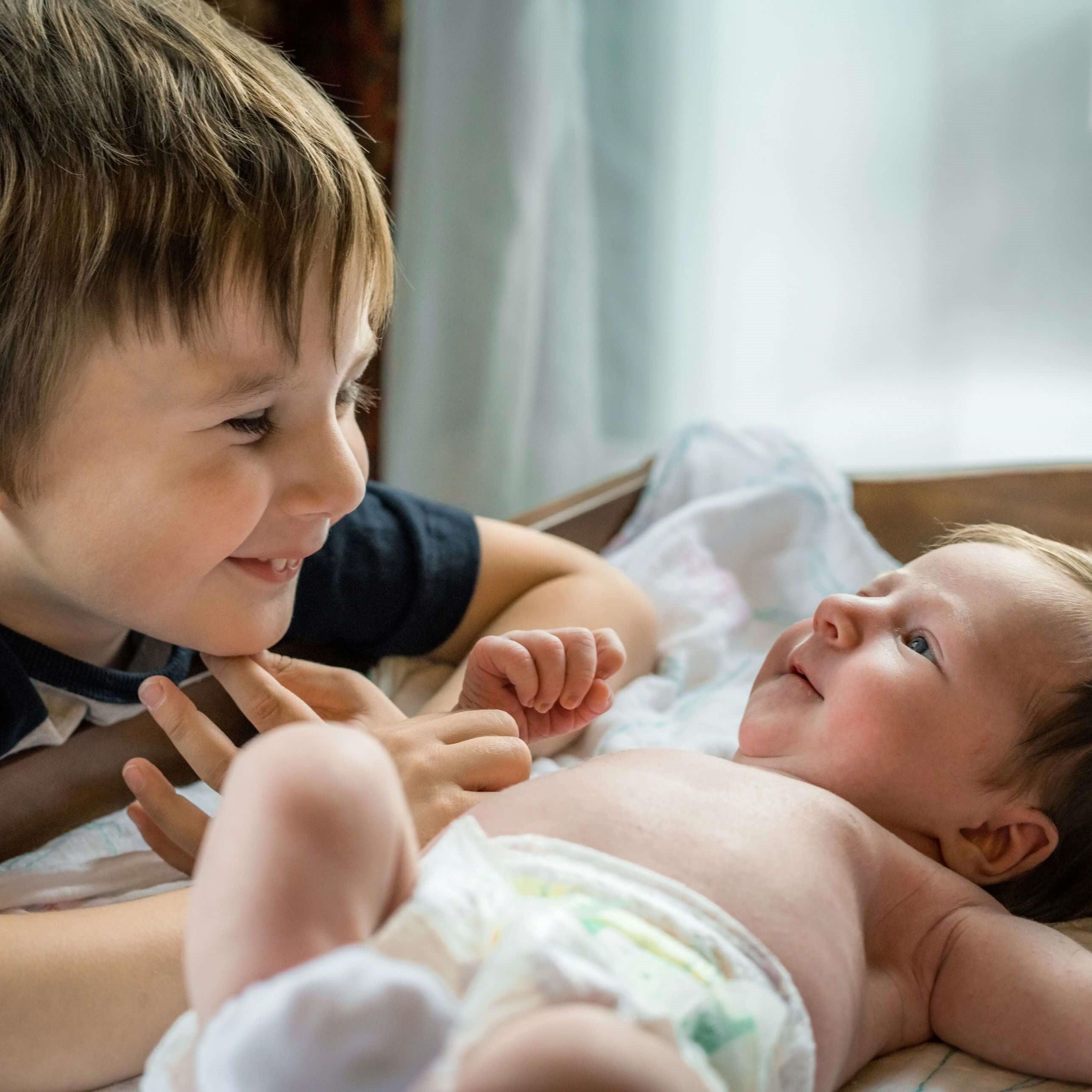 Little boy meeting his cute baby sister
