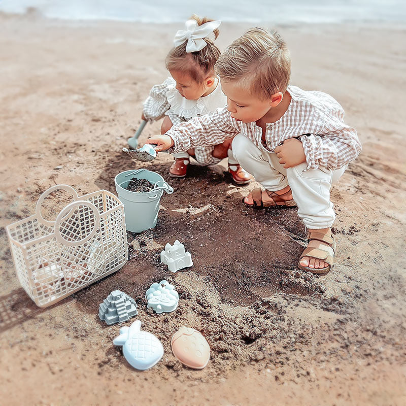 Two kids are playing Moonkie Beach Toy Set