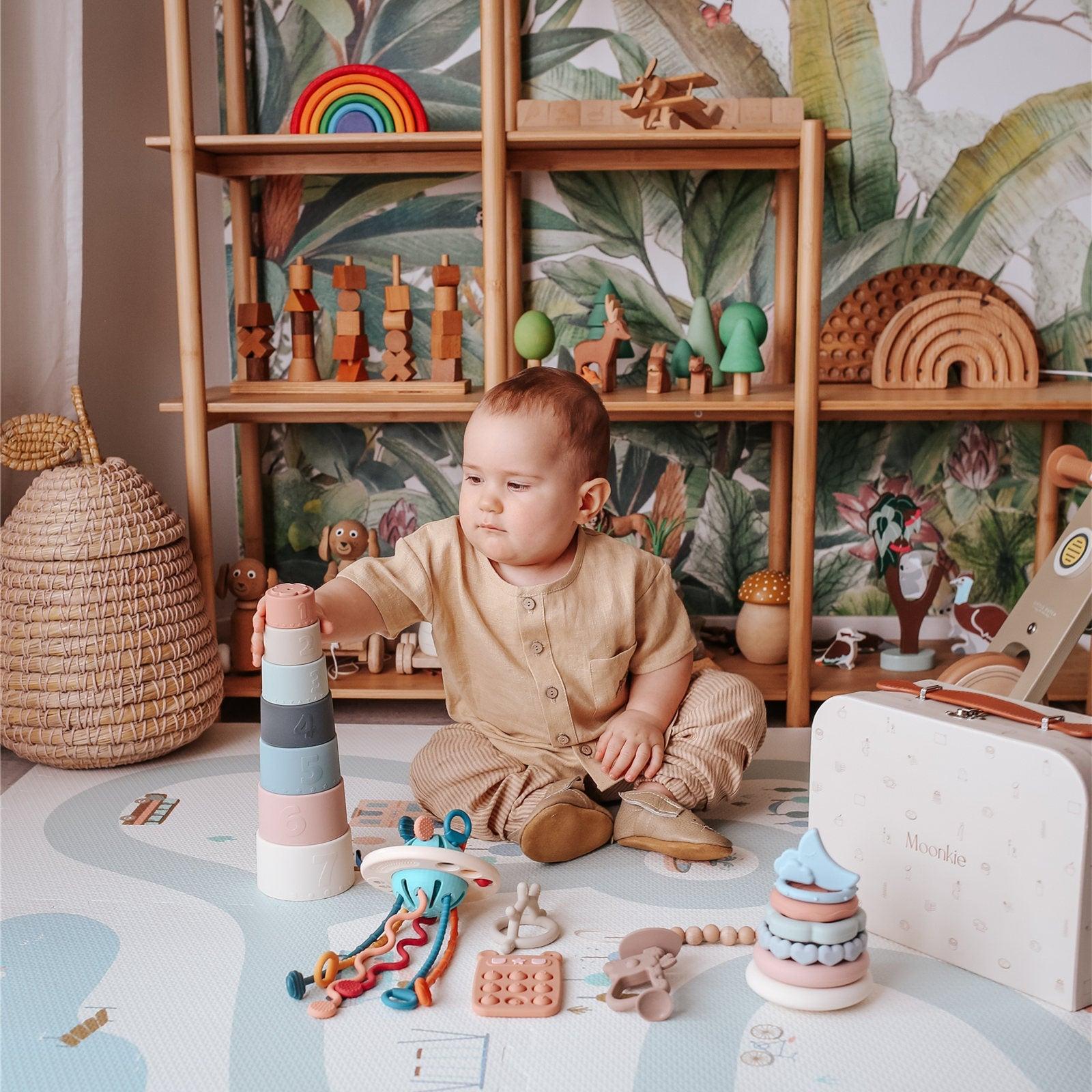 A baby is palying Moonkie Stacking toys