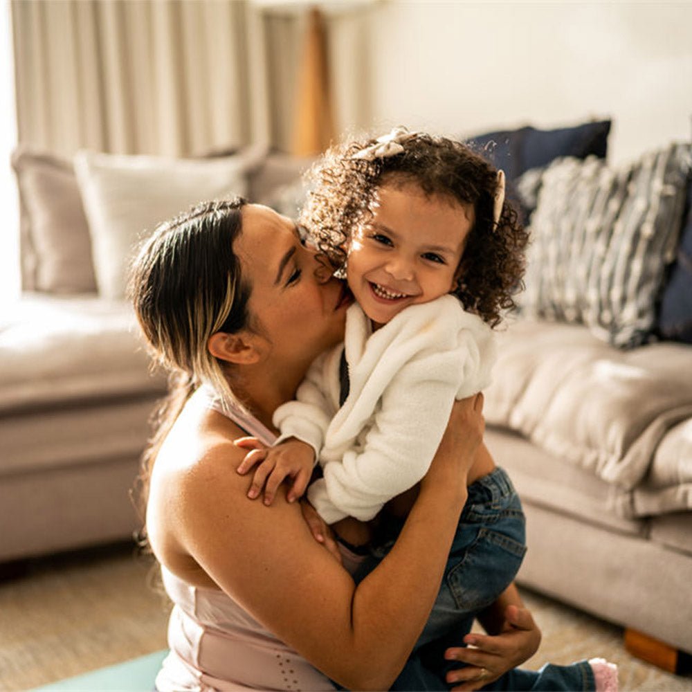 Portrait of toddler girl having fun with her mother in the living room at home