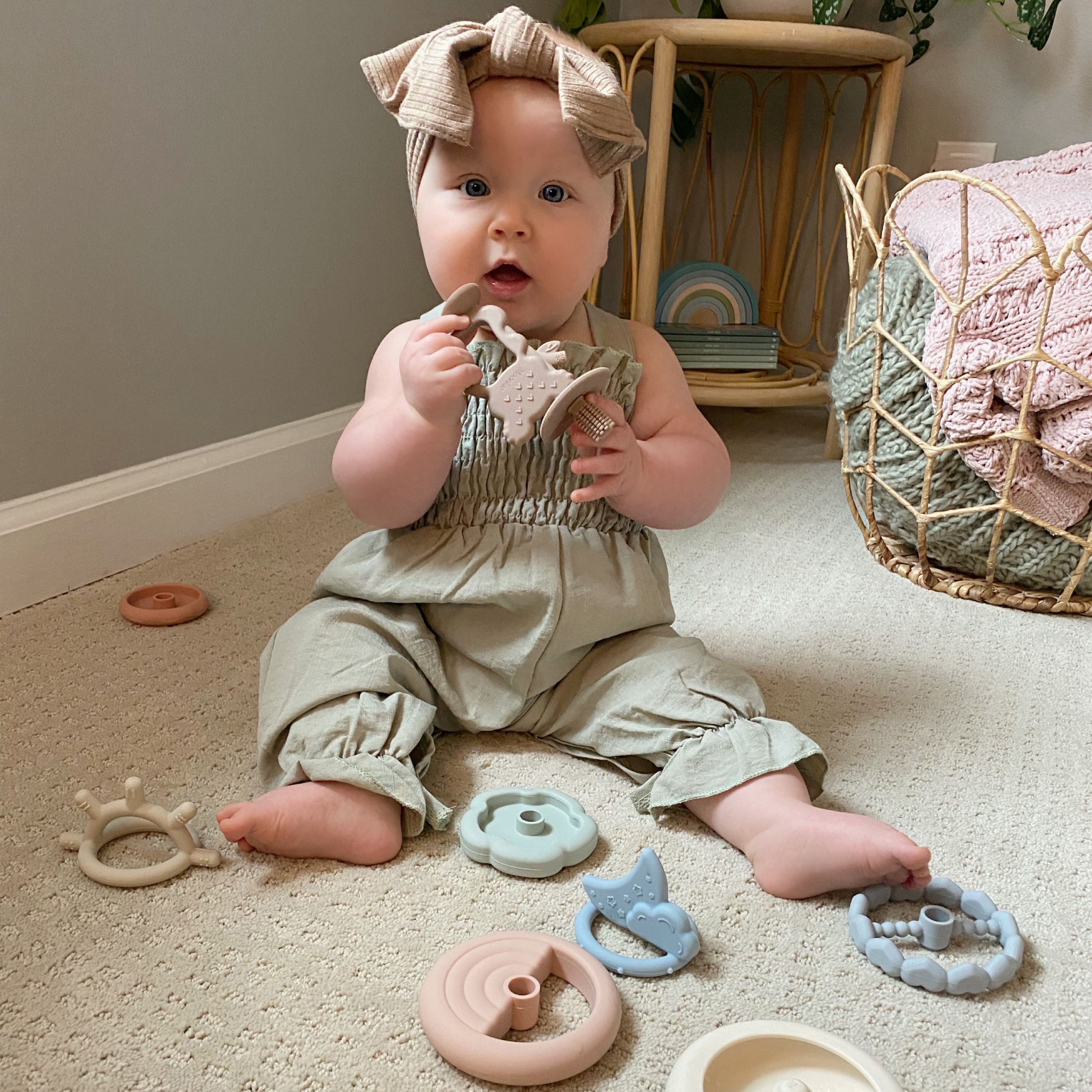 A baby is playing Moonkie's teething ring