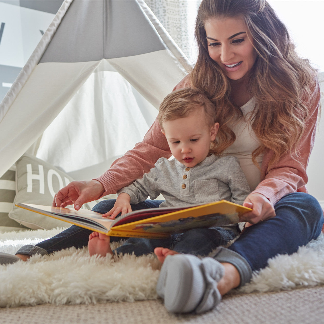 A woman reading to her toddler son at home