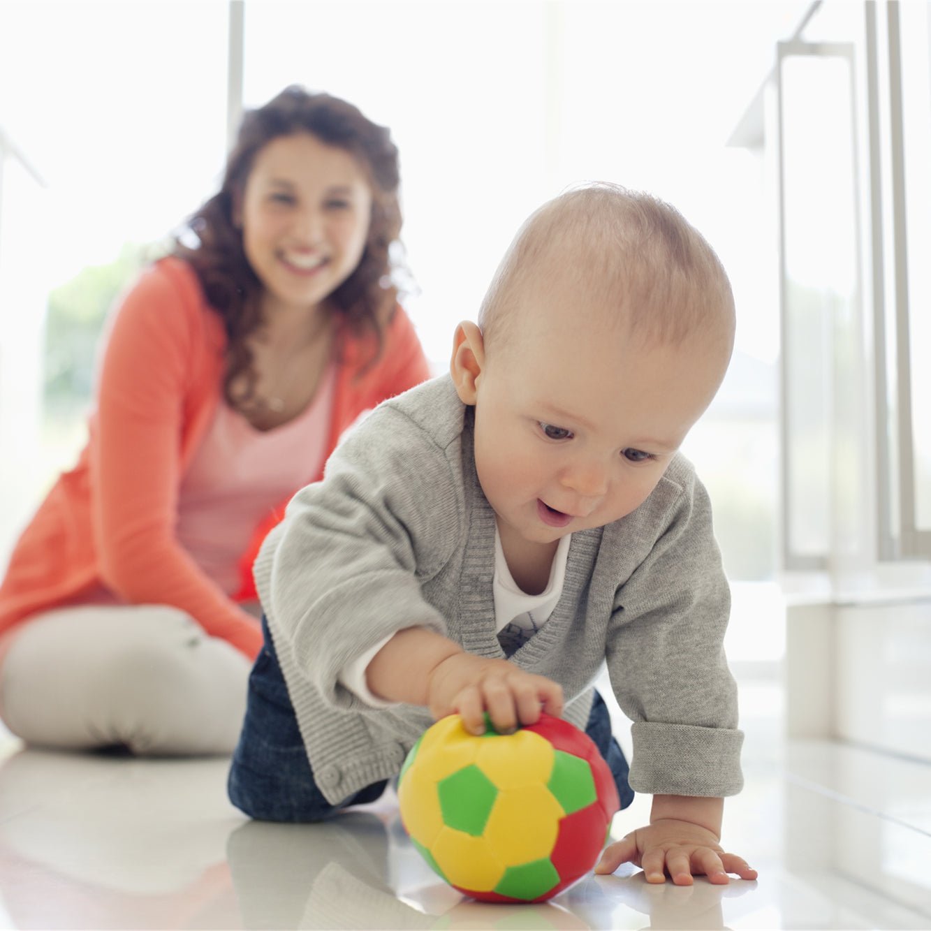 Baby playing ball on the floor