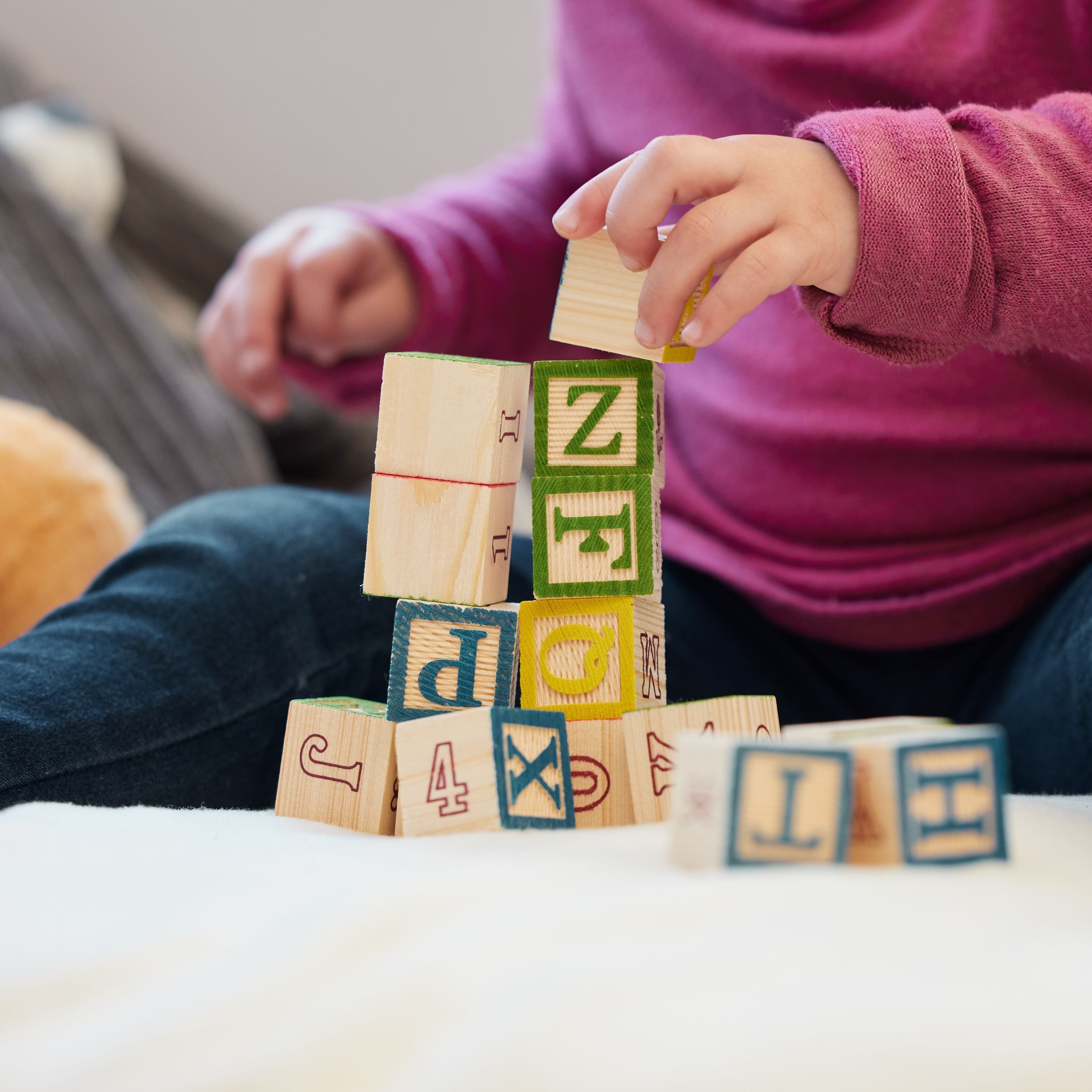 A baby is palying Alphabet Letters Number Stacking Blocks Set