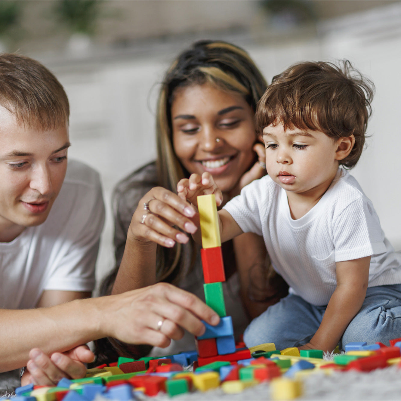 Parents and their baby is playing Montessori stacking toys