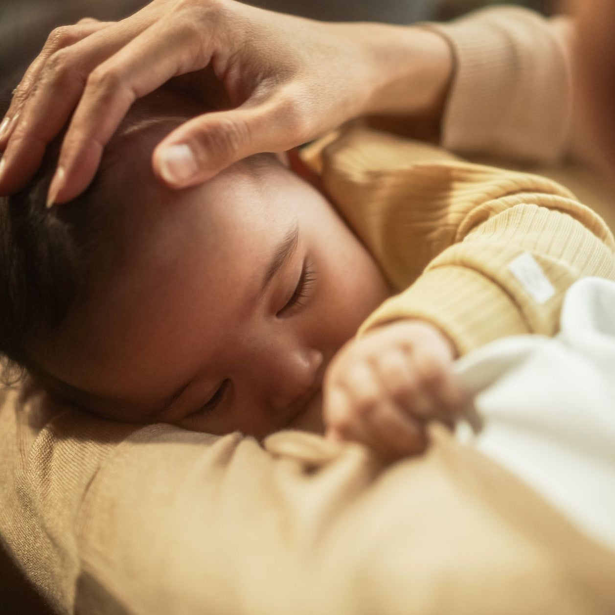 A baby fell asleep in mom’s arms.