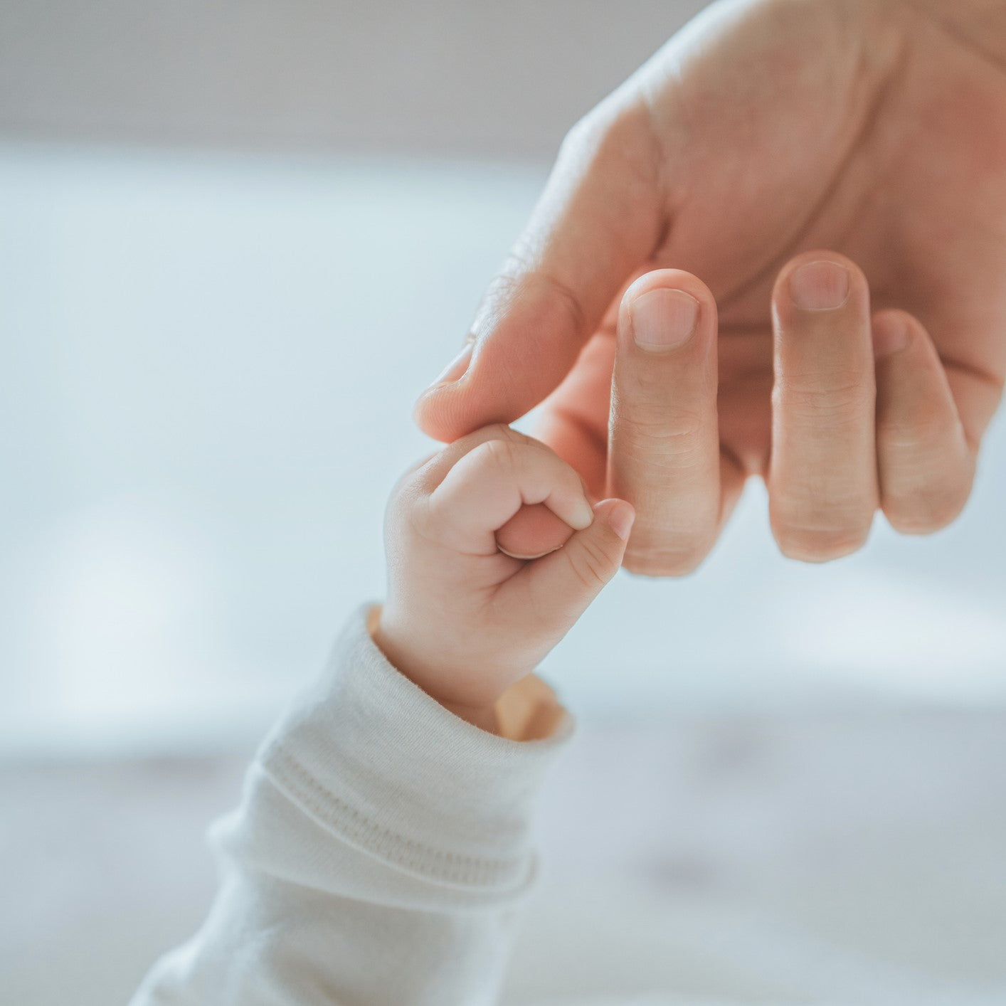 A newborn holds on to mom's, dad's finger, Love and relationship with infant