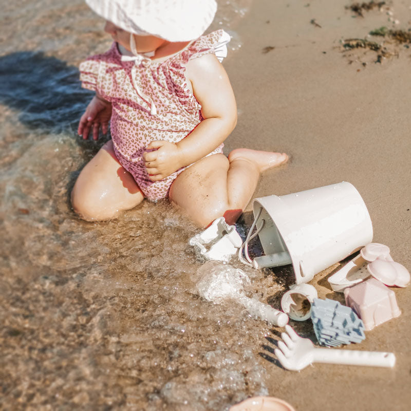 Baby playing with beach toys at the beach