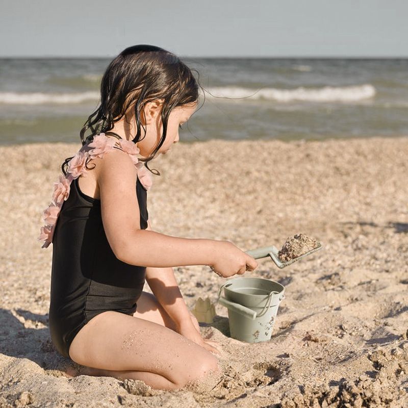 Baby playing with Ether beach toys at the beach