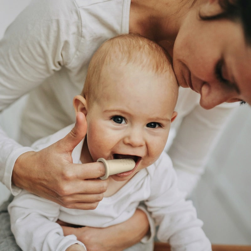 Mom Using Finger Toothbrush For Baby