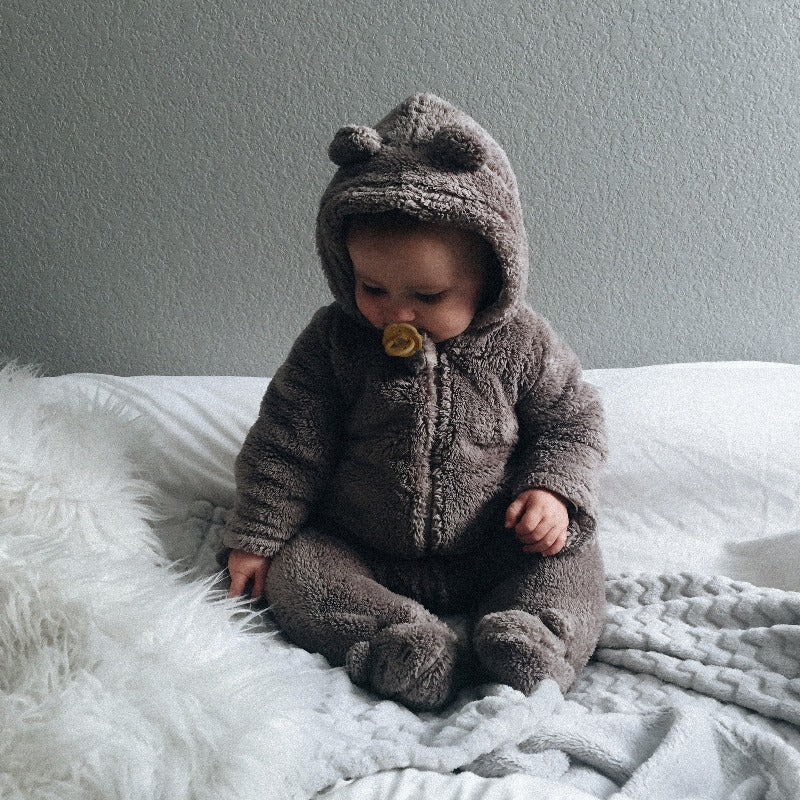 Baby in gray sweater using the pacifier