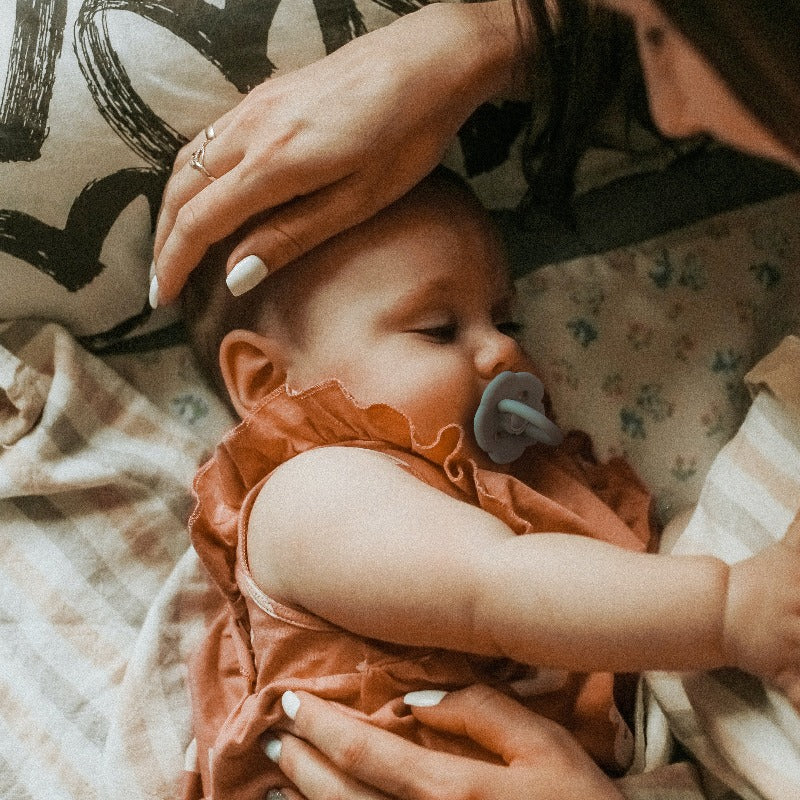 Baby  Using Silicone Baby Pacifier Under mom's care.